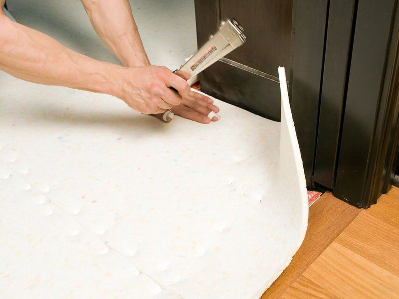 Person installing flooring underlayment from Adair's Brunnerville Flooring in the Lititz, PA area