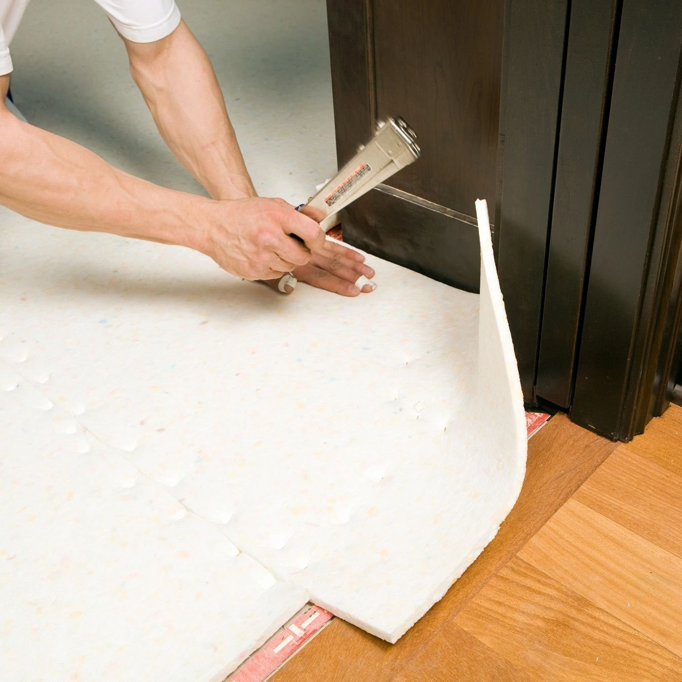 Person installing flooring underlayment from Adair's Brunnerville Flooring in the Lititz, PA area